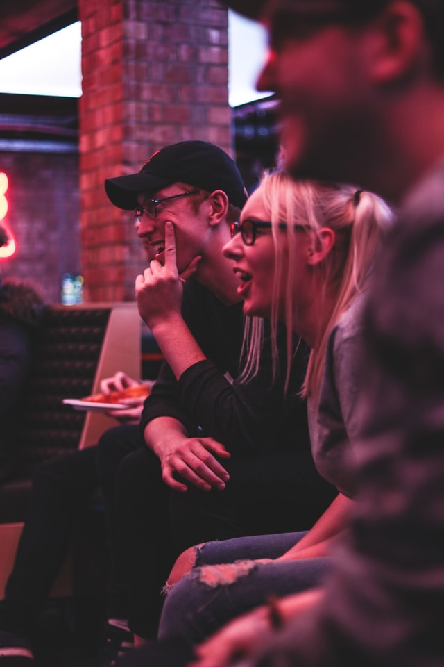 Woman sitting between two smiling men.